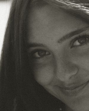 Black and white portrait showing a soft smile and natural lighting.