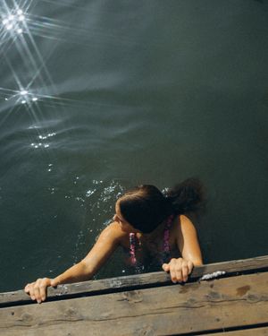 A sequence of images showing hands desperately grasping the edge of a wooden dock or platform above dark water.