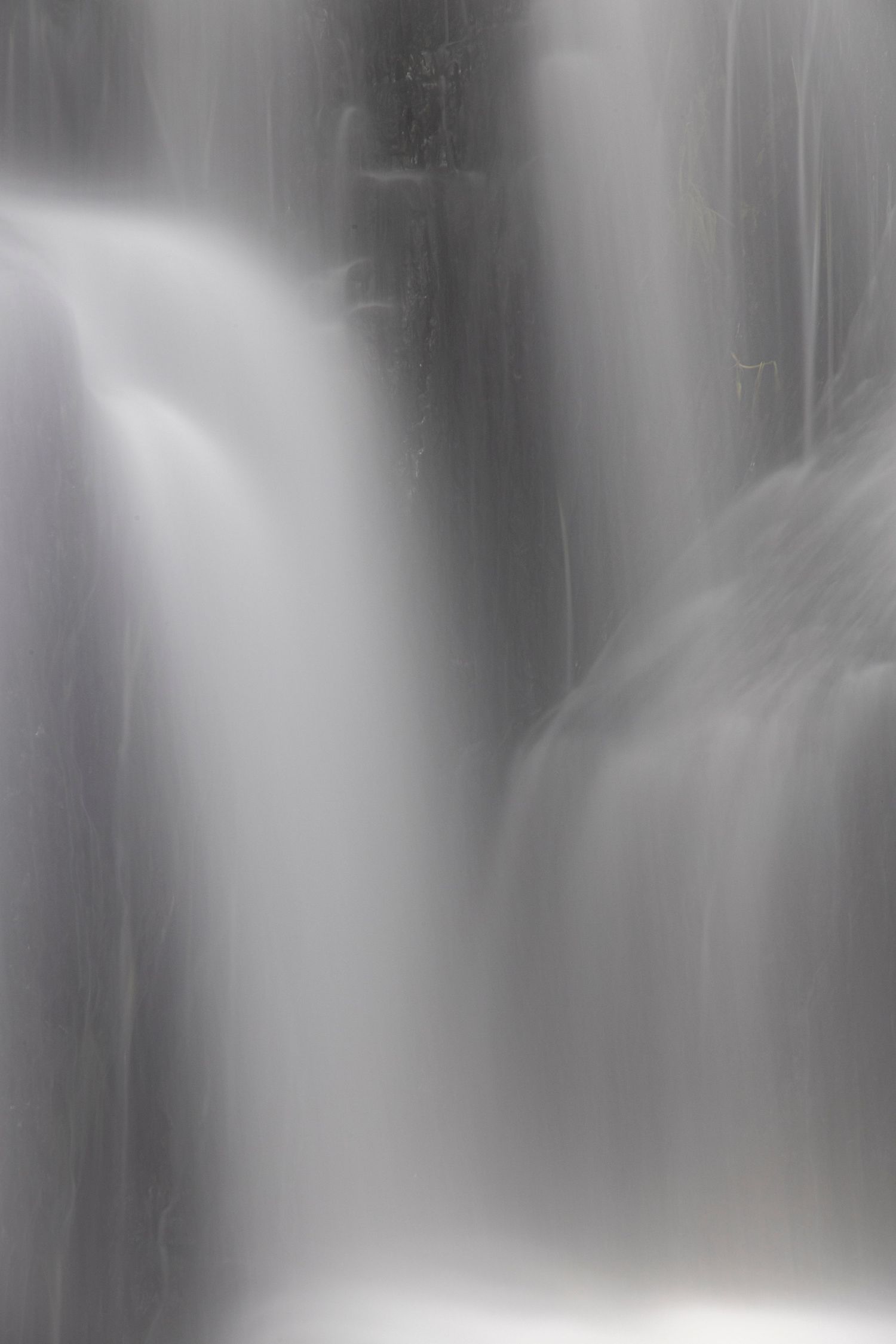 Soft-focus close-up of cascading waterfalls with silky smooth water effect, captured using long exposure.