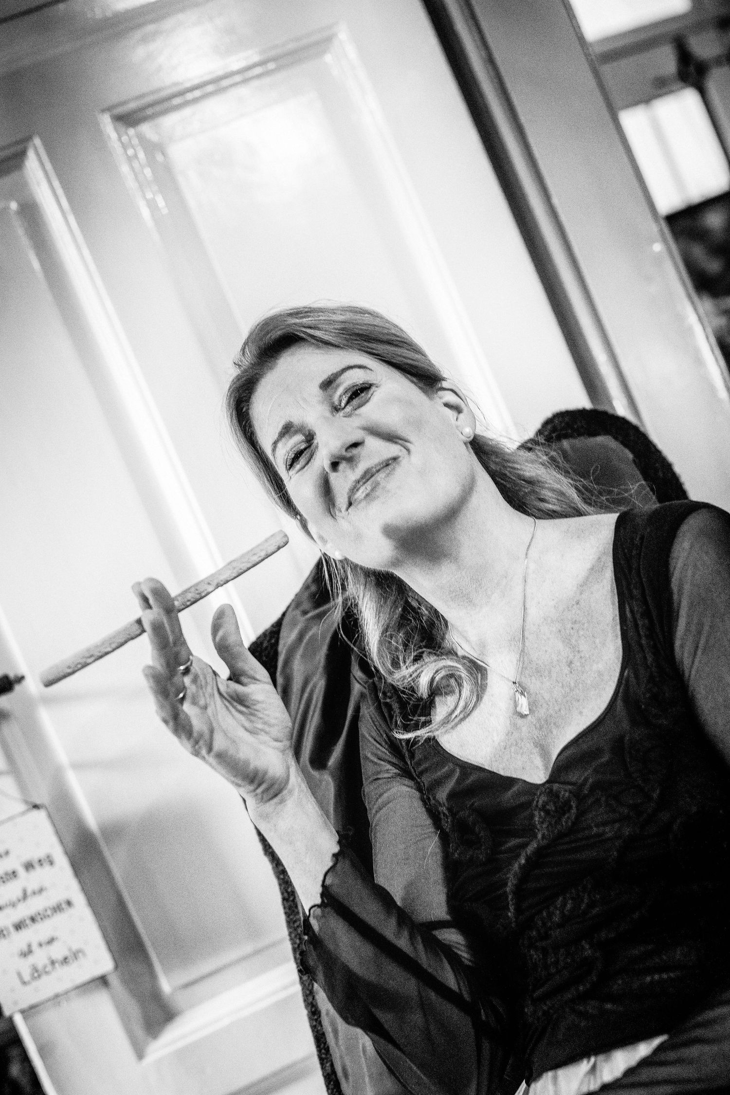 Portrait einer Frau ein wenig lustig mit einer Käsestange gehalten wie eine Zigarette im Fotostudio Aurelia Schulz