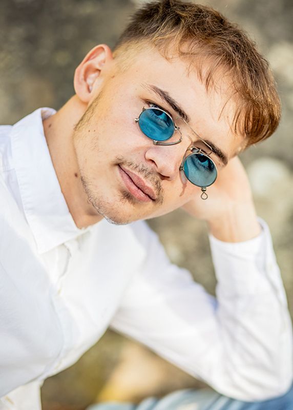 Portrait eines modernen jungen Mannes outdoor mit blauer Sonnenbrille