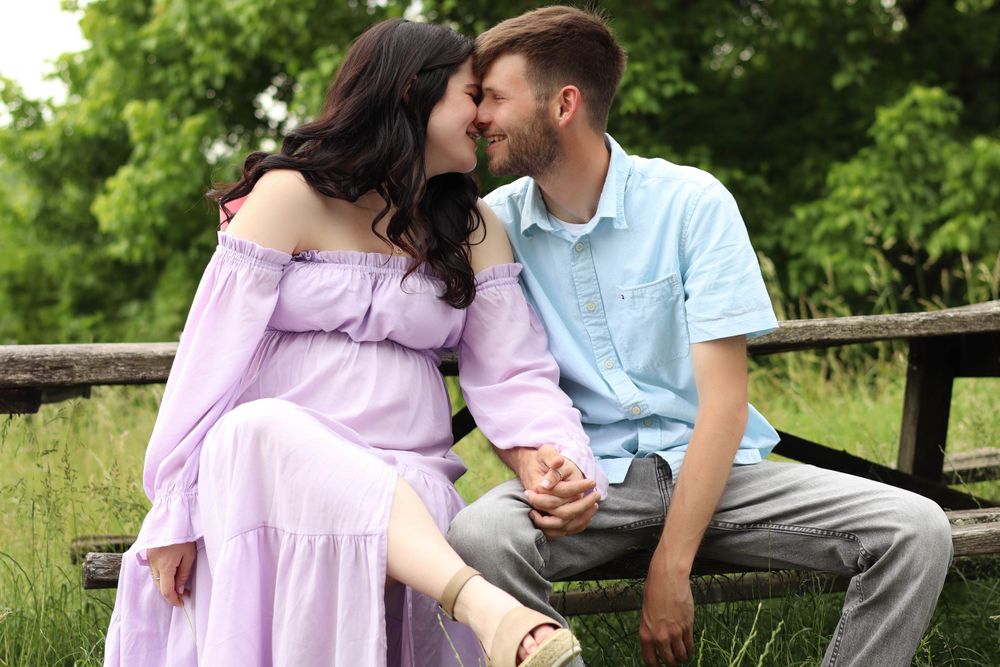 Intimate moment between couple during outdoor maternity photoshoot.
