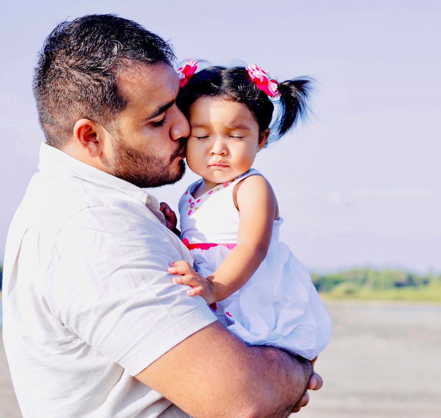 A tender moment captured between parent and child against a light background.