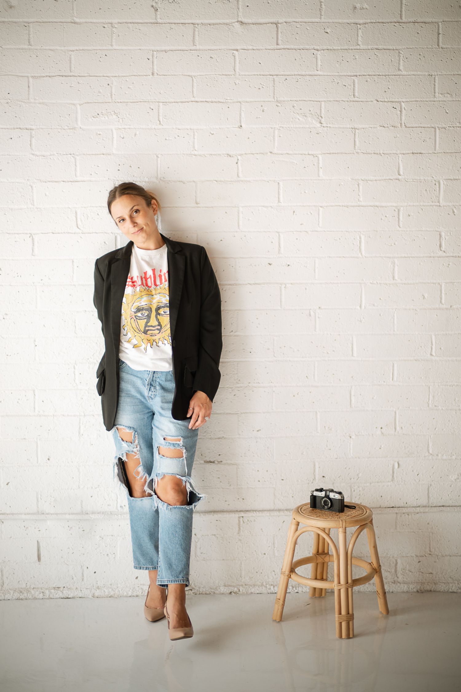 Candid fashion photography session featuring casual styling and minimalist white brick backdrop.