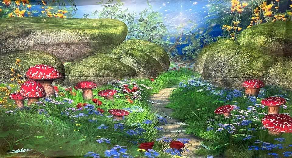 Whimsical garden path with red mushrooms, wildflowers, and moss-covered rocks.
