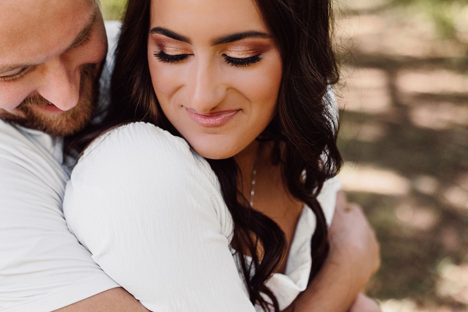A tender embrace captured in warm sunlight showing a close intimate moment.