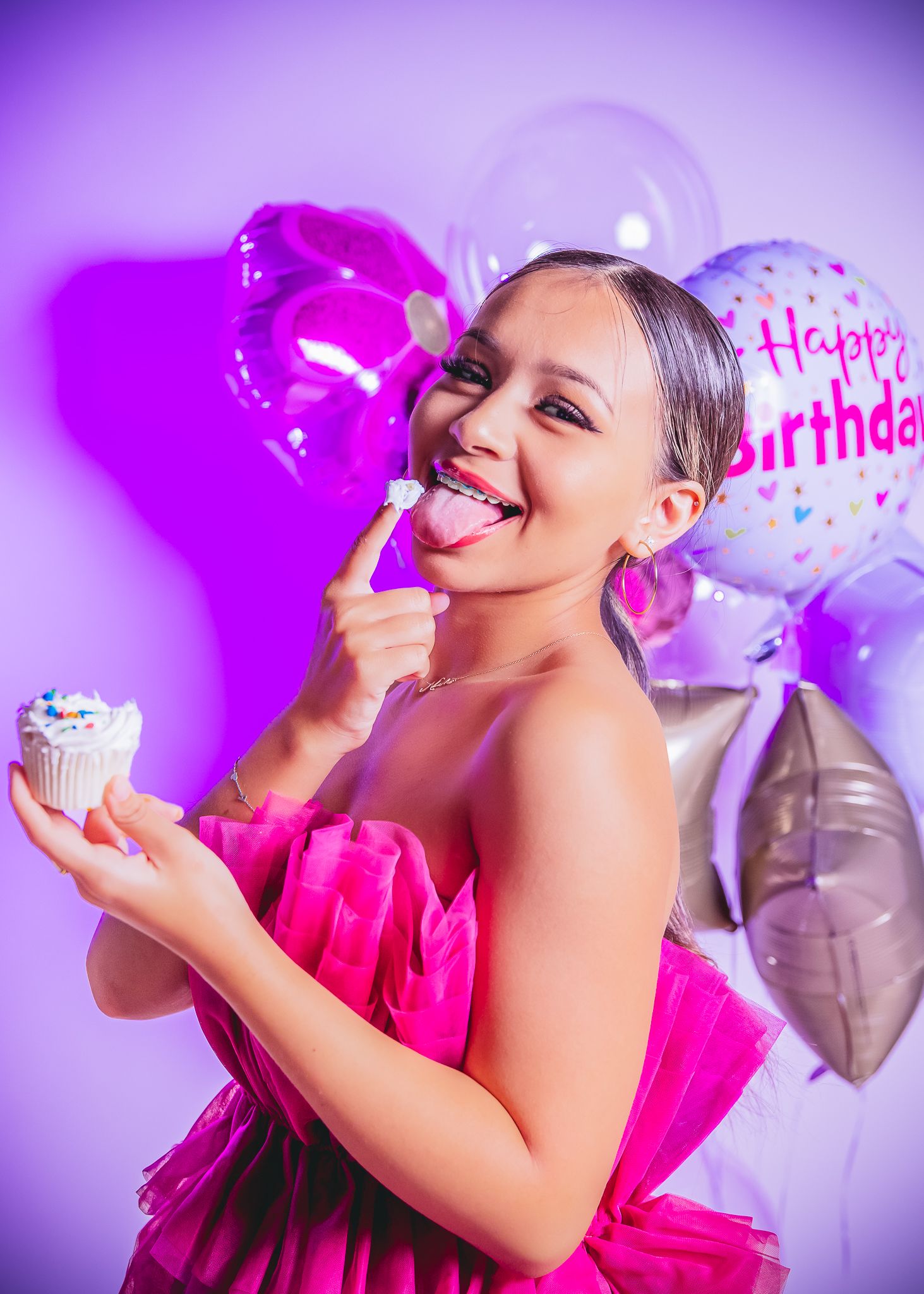 studio photoshoot of a 15 year old birthday girl holding her crown with balloons surrounding her in a Greeley Colorado studio