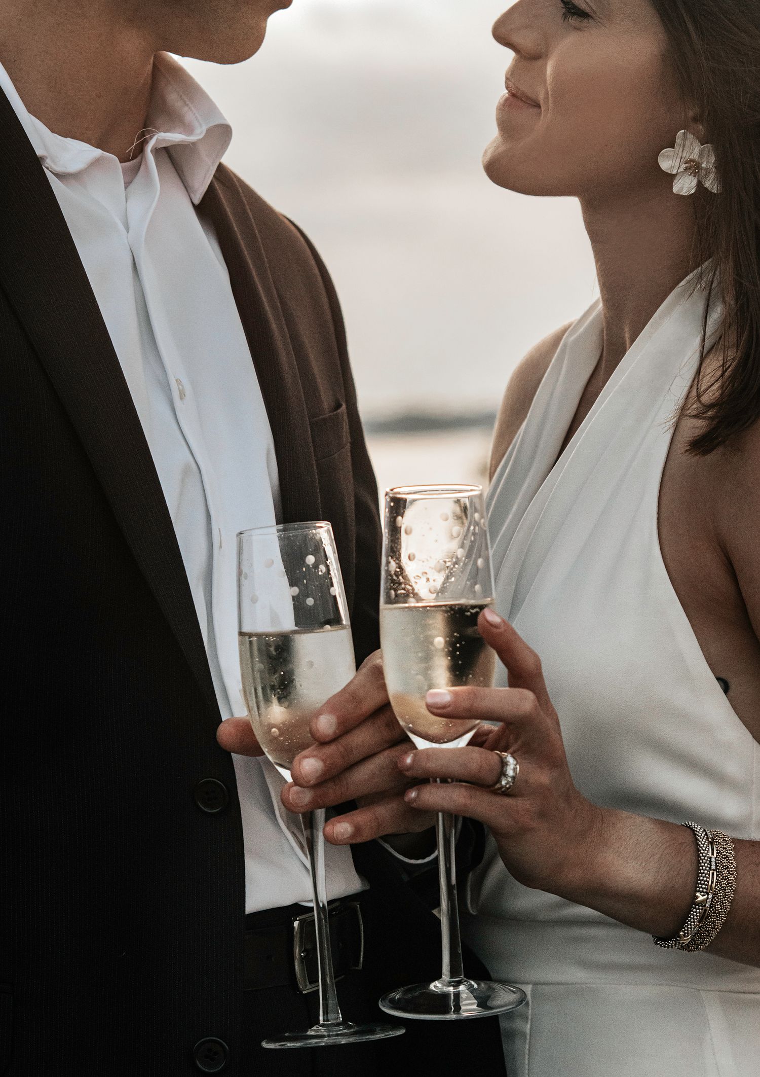 Romantic couple sharing champagne toast in formal attire.