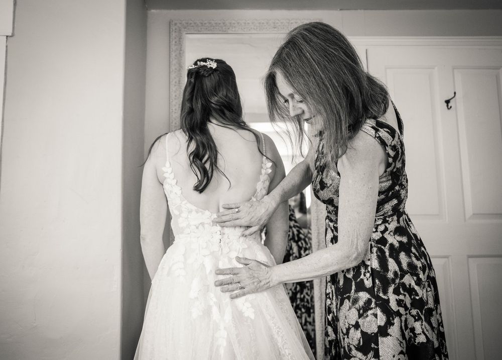 Black and white photos showing emotional moments during a wedding dress fitting.