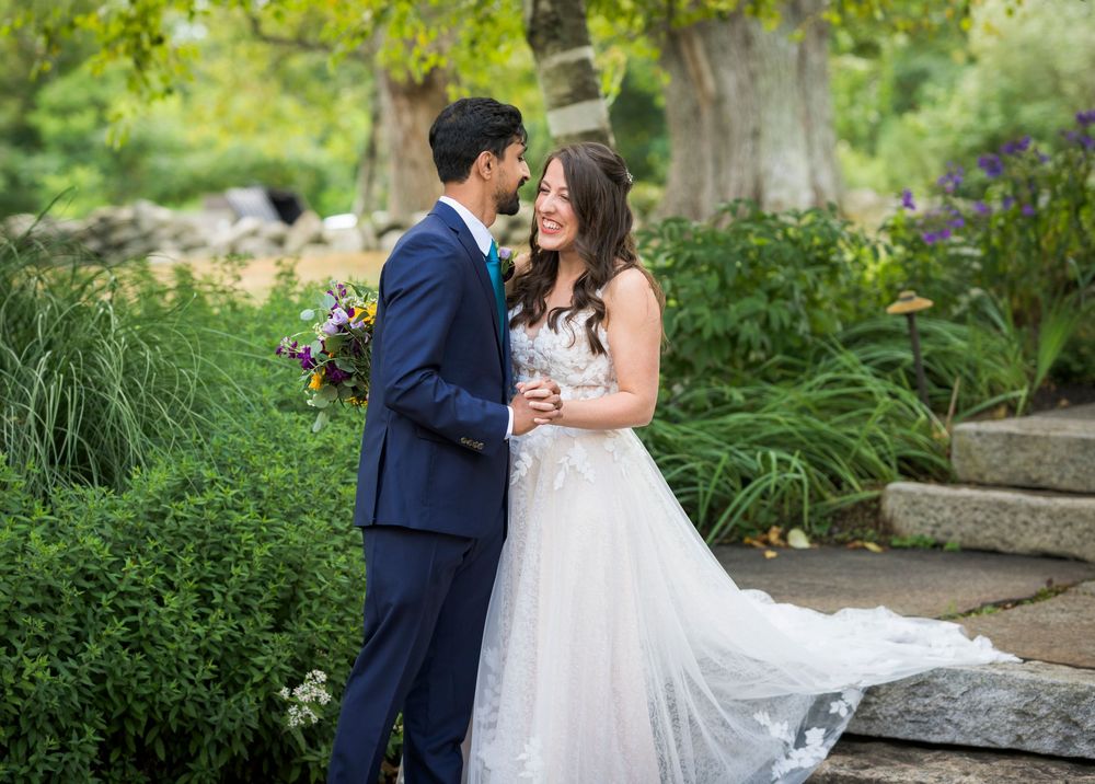 Romantic garden wedding portraits among lush greenery and stone steps.