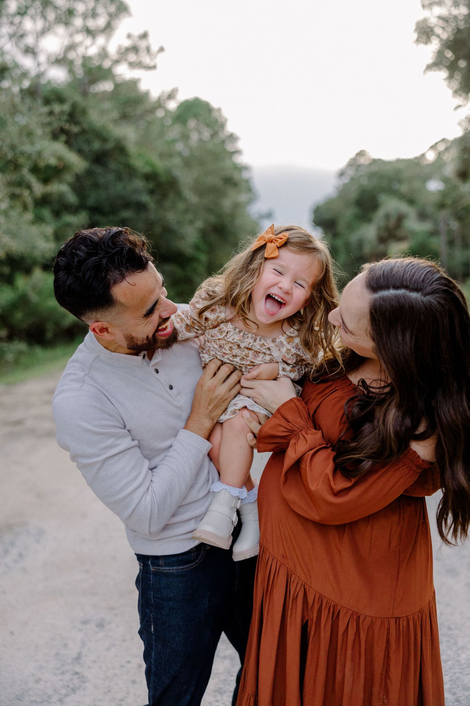 A warm family lifestyle photo series showing playful candid interactions and joyful moments together outdoors.