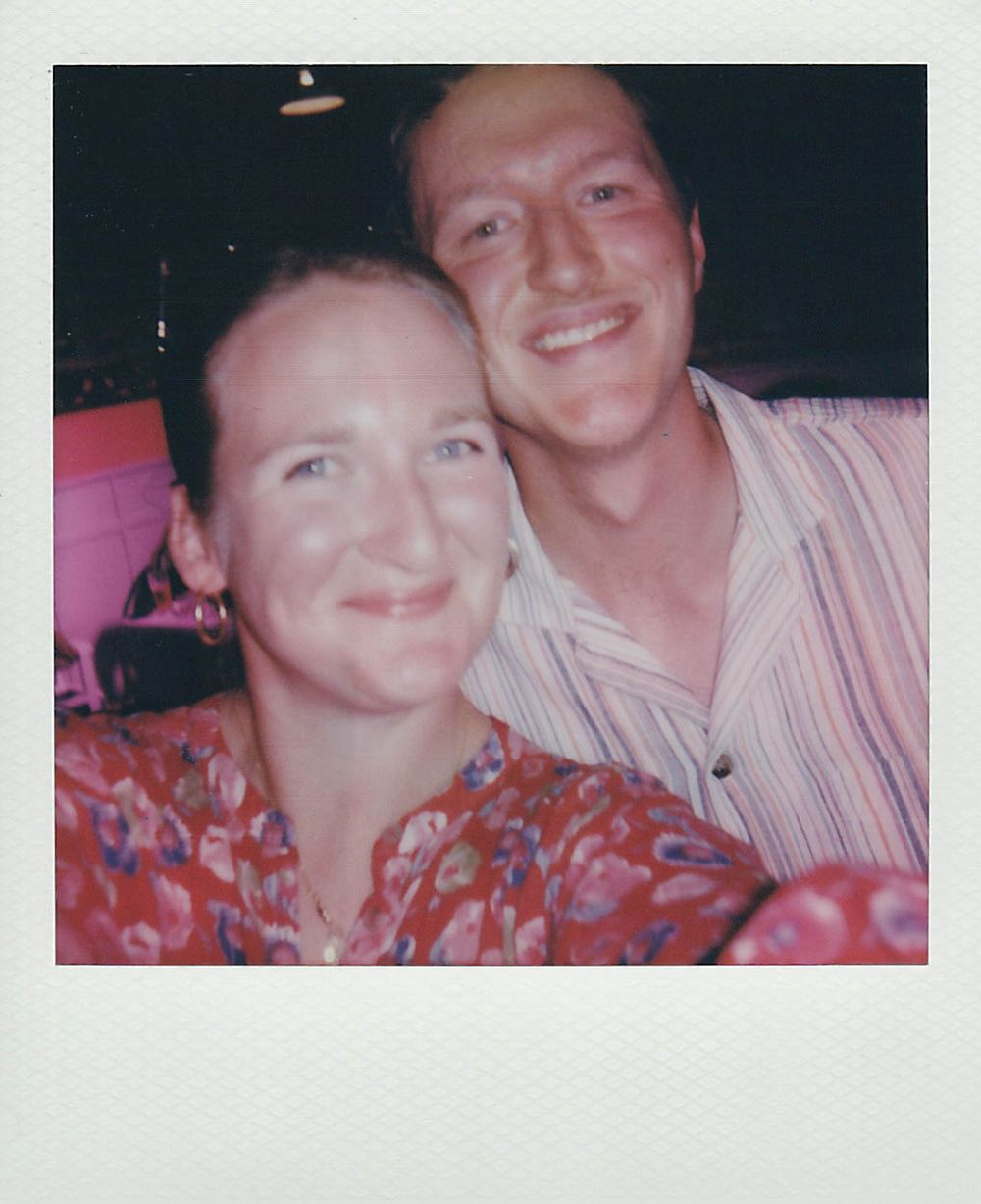 Vintage polaroid style photo of couple smiling together at night.
