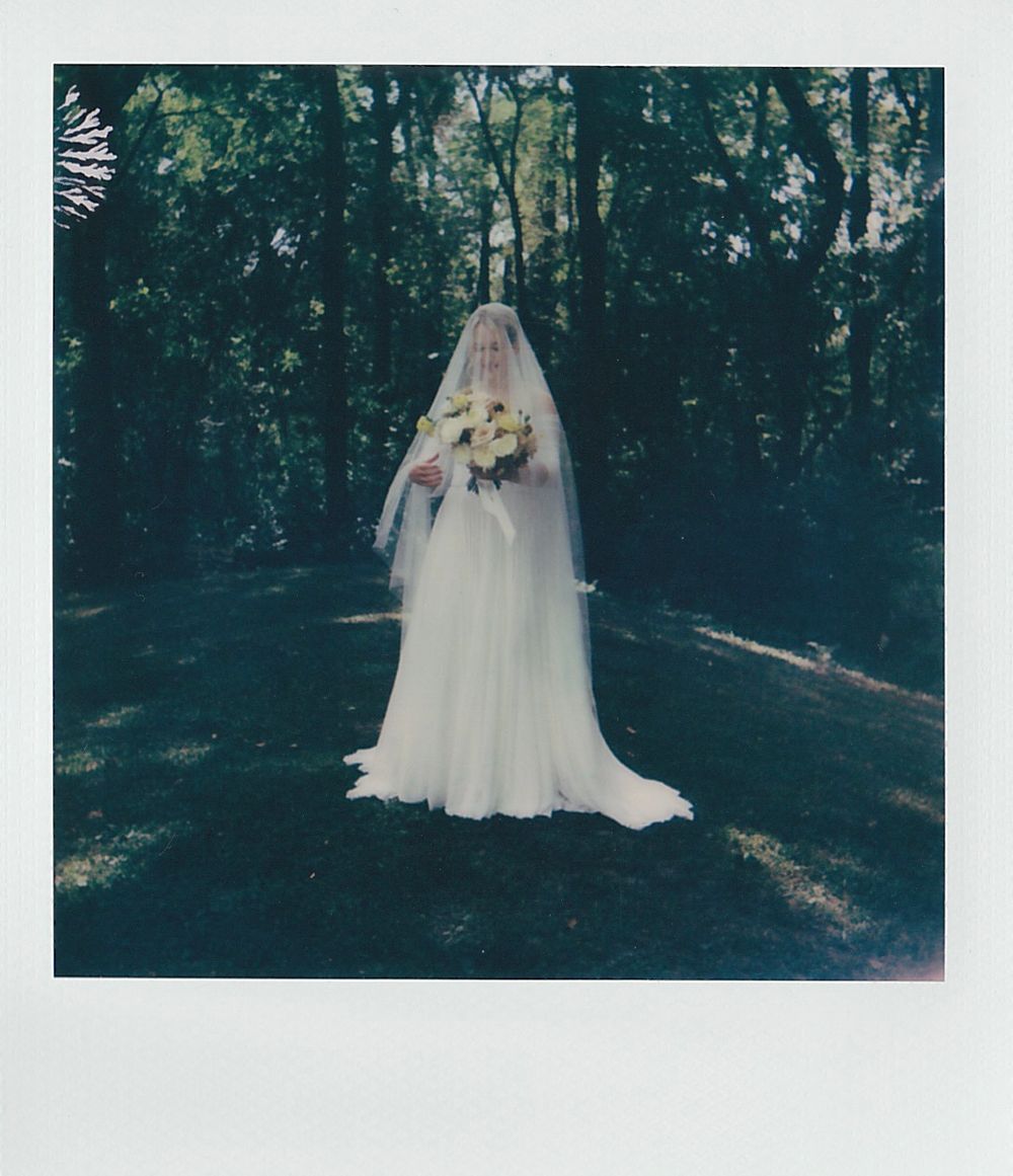 Ethereal white wedding dress photographed in a moody forest setting.