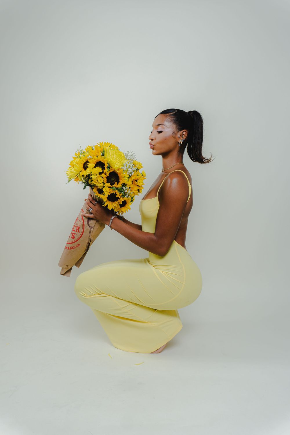 Artistic photo series showing graceful poses with sunflower bouquet and yellow dress.