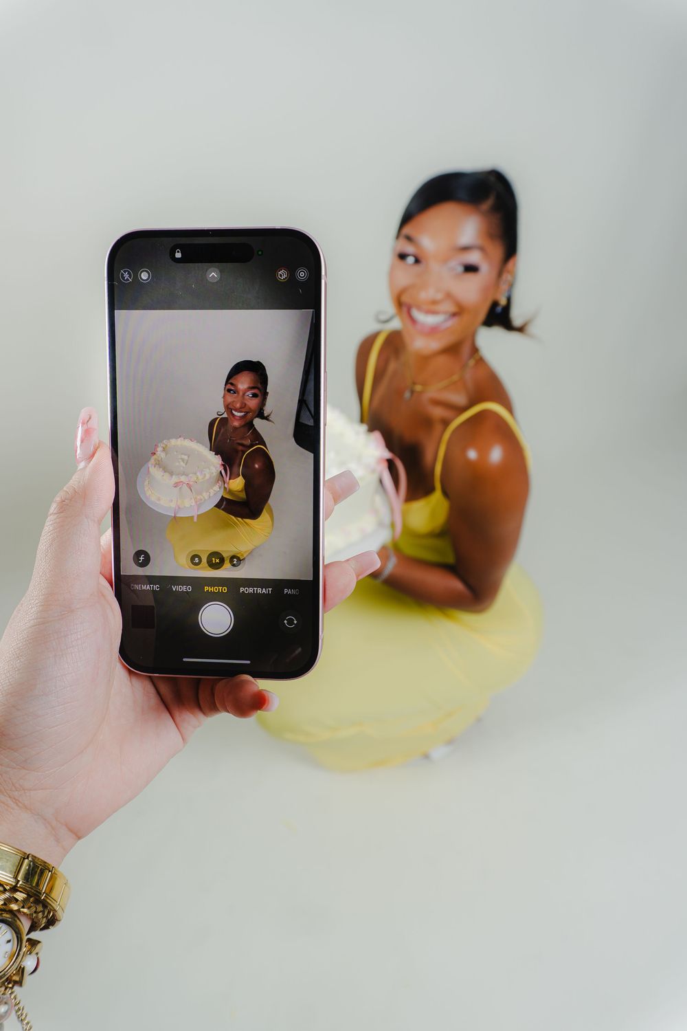 Behind the scenes photo showing smartphone capturing birthday photoshoot moment.