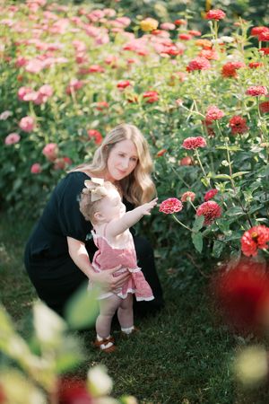 A pair explores blooming pink and red zinnias in a summer garden.