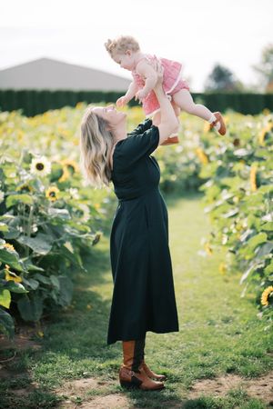 A joyful moment captured between two people in a sunflower garden on a bright day.
