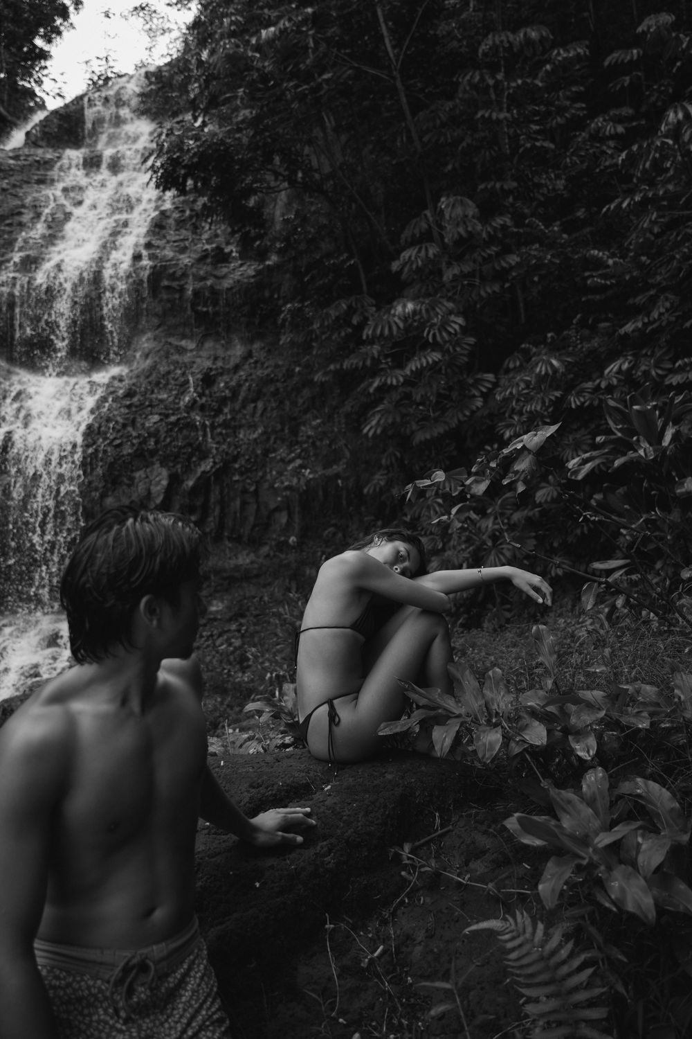 Couple swimming at a Kauai waterfall captured by a travel photographer in hawaii