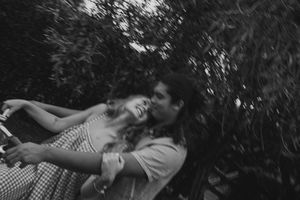 Playful couple riding bikes through a lush forest in Kauai, Hawaii during their engagement session