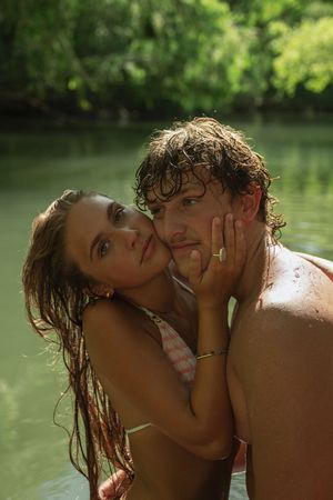 Adventurous couple swimming in a green lake in southern utah for a fun engagement session