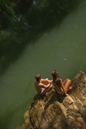 Adventurous couple swimming in a green lake in southern utah for a fun engagement session