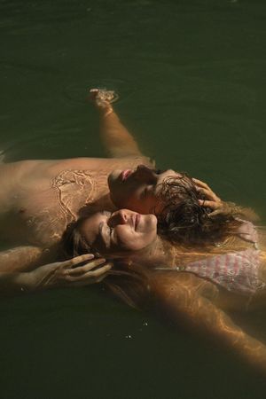 Adventurous couple swimming in a green lake in southern utah for a fun engagement session in the summer