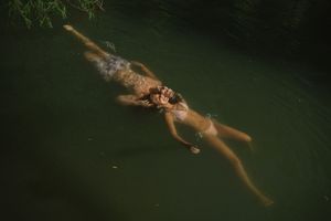 Adventurous couple jumping into a Utah lake during summer photoshoot