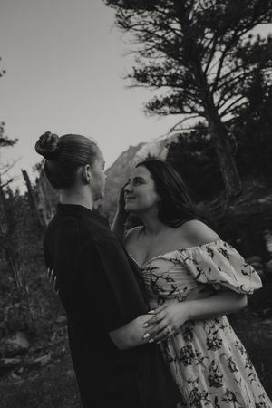Lesbian couple looking into each other's eyes in the Utah mountains at their engagement photoshoot