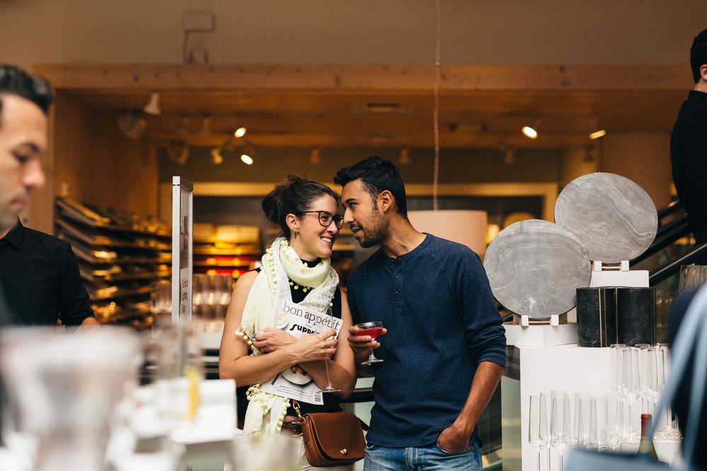 Guests mingling at an indoor event space with white decor and ambient lighting.
