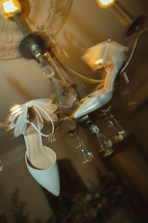 Bride and groom's shoes hanging off of chandelier at The Bentley House in St. George, Utah