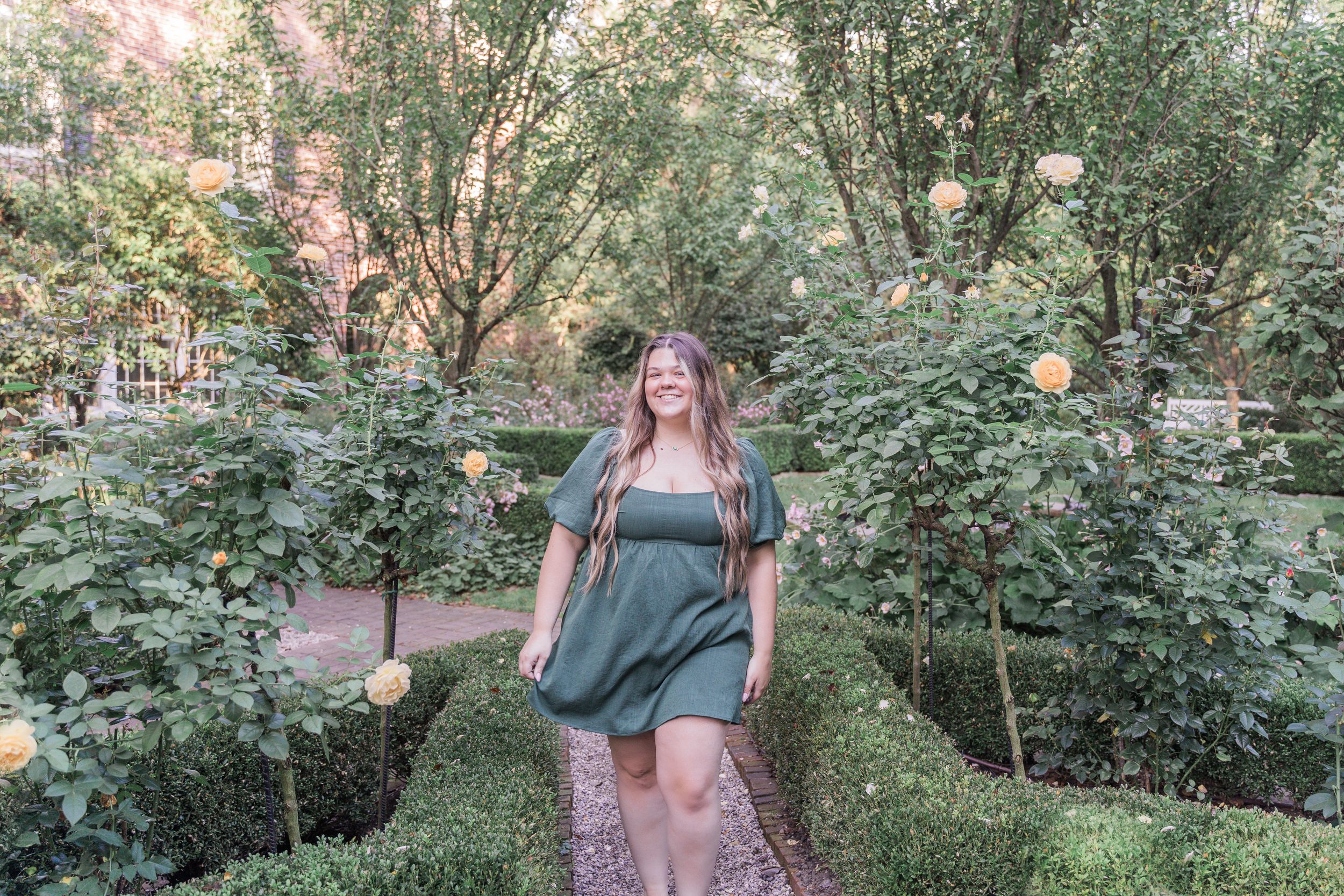 Professional outdoor photography session in a lush garden setting with soft natural lighting and greenery.
