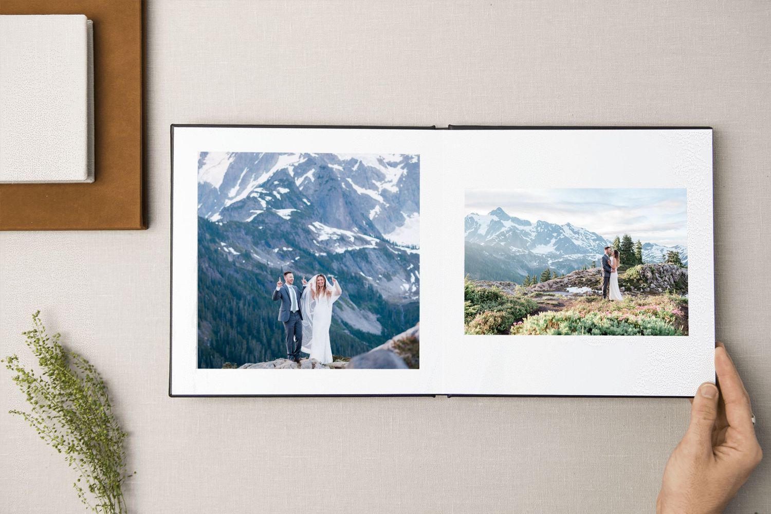 image of wedding albums with one opened up showing two photos of a couples in the mountains
