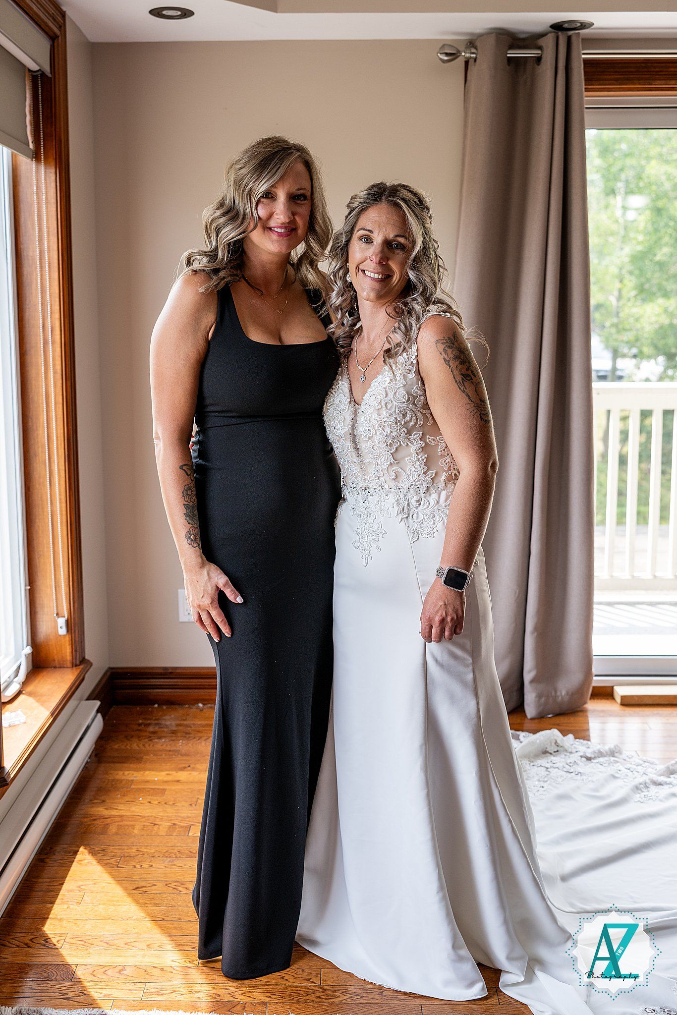 Two people share a joyful moment indoors while wearing formal attire with sunlight streaming through windows.