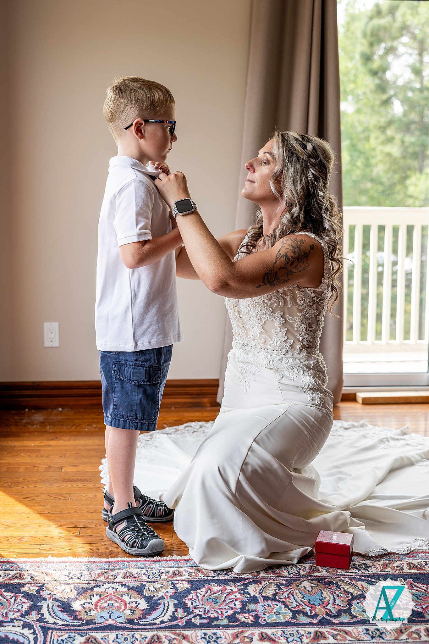 A tender moment between two people sharing a special wedding day interaction on a hardwood floor with floral rug.