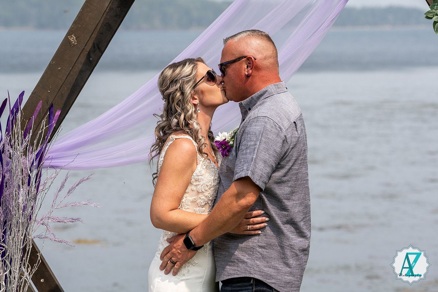 Romantic lakeside wedding ceremony with purple accents and waterfront backdrop.