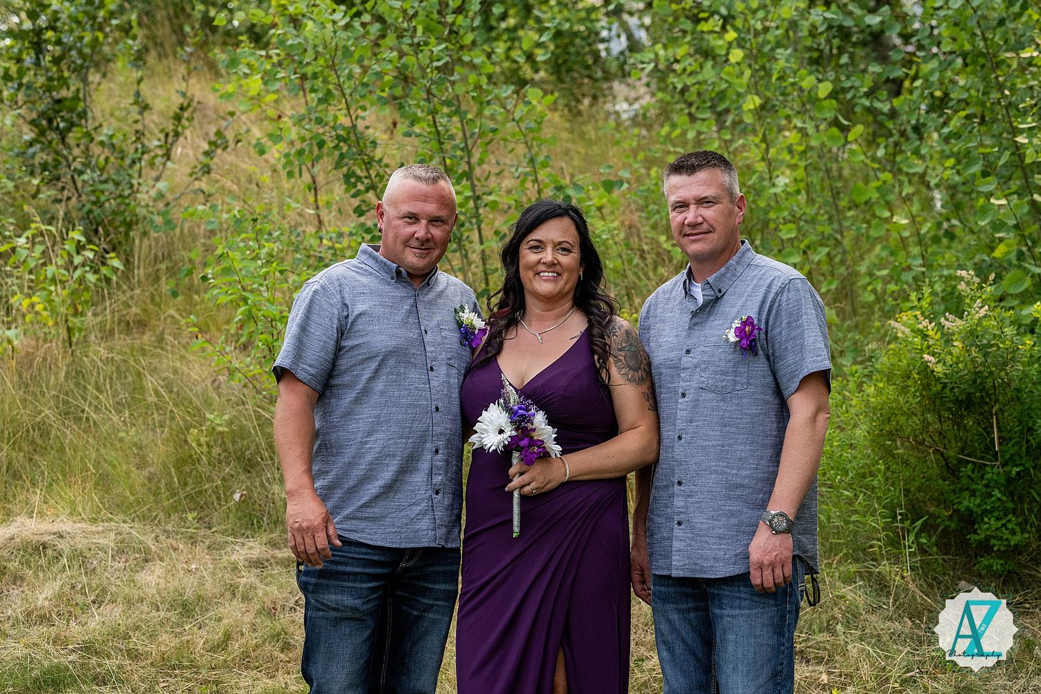 Three people stand together outdoors against a natural green background in coordinating casual outfits.