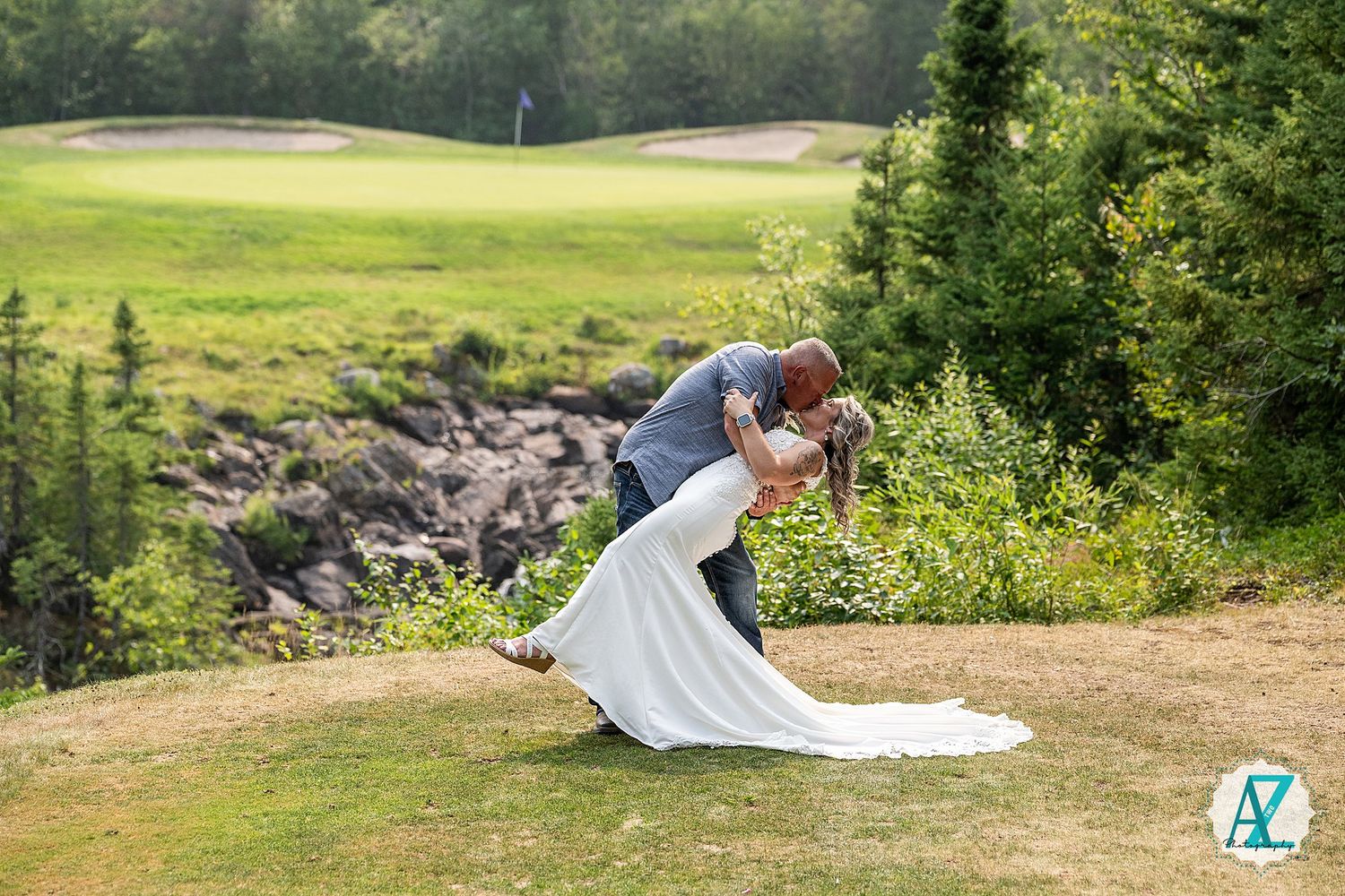 A wedding couple poses together on a lush green golf course during their summer outdoor photo session.