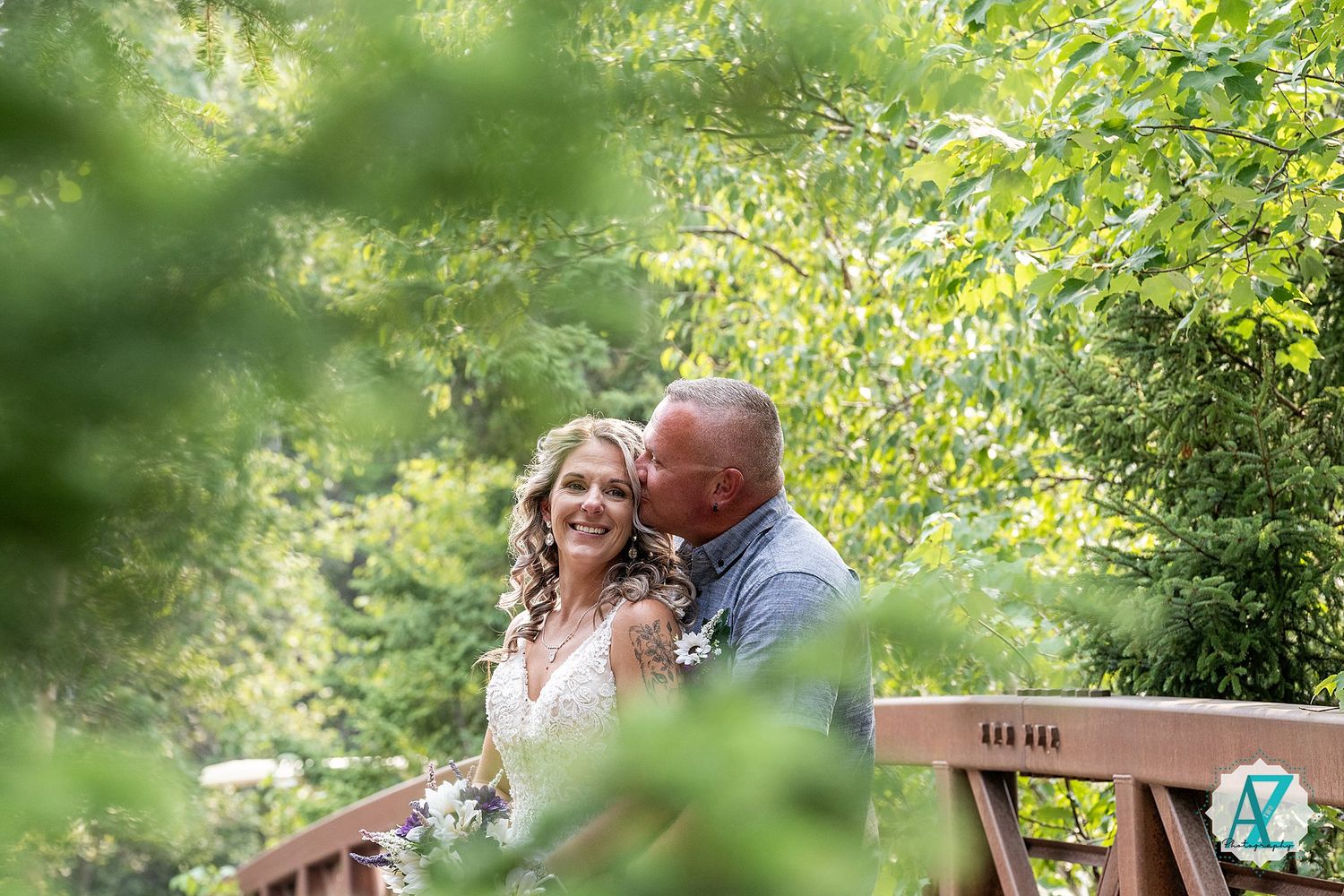 A couple shares a romantic moment in a lush garden setting during a summer wedding celebration.