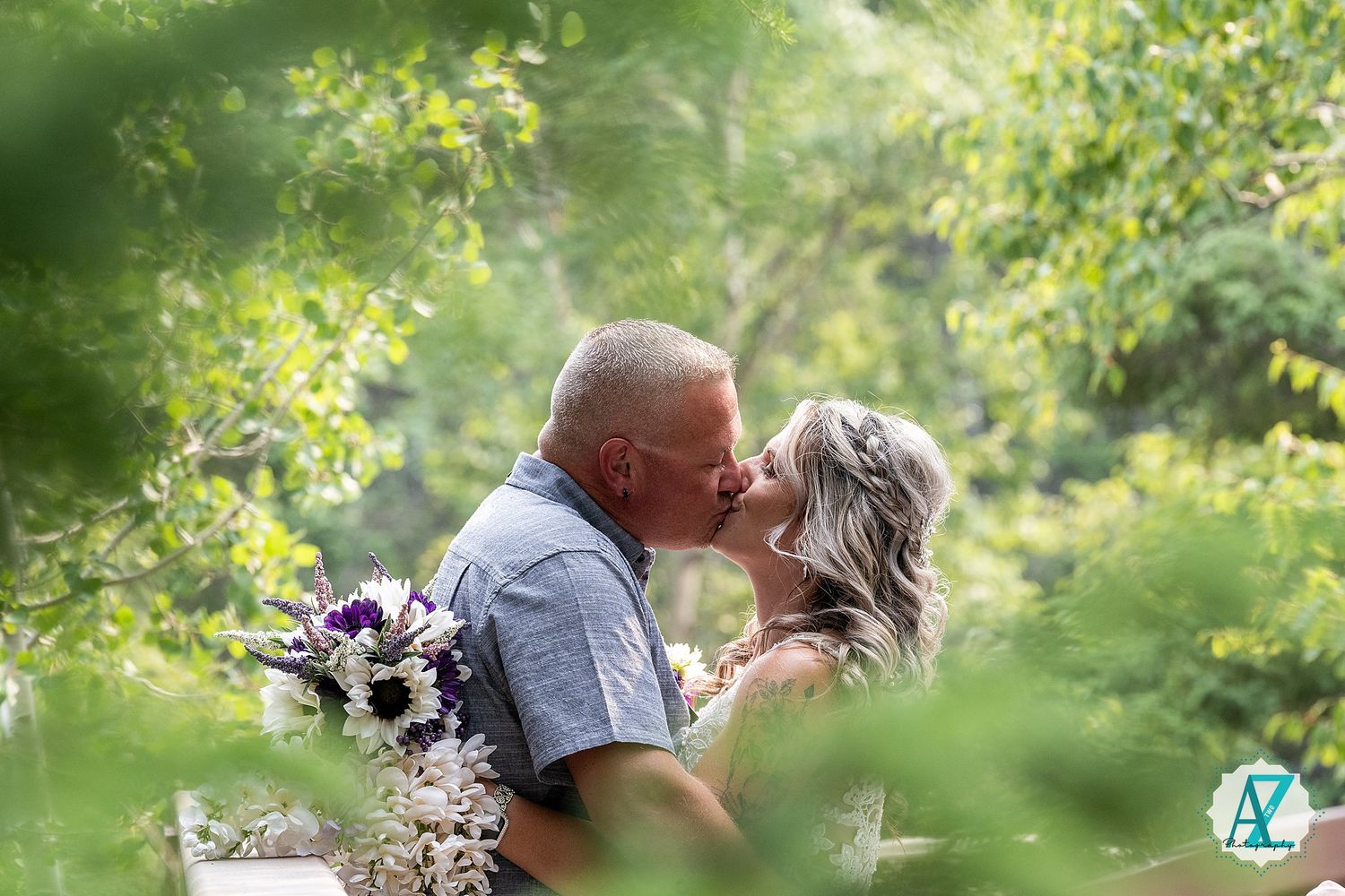 A romantic couple kissing in a lush garden setting with natural sunlight filtering through the trees and greenery.