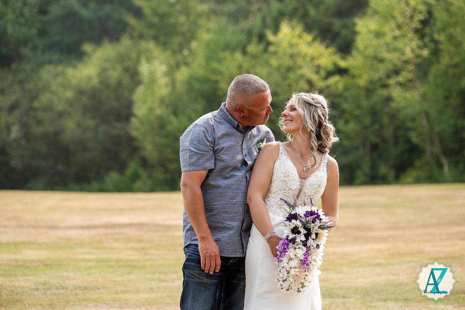 A couple shares romantic moments in a sunny meadow while taking engagement or wedding photos outdoors.