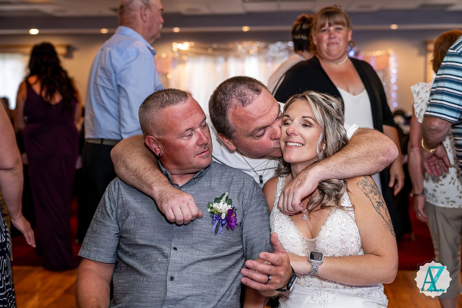 People share emotional embraces and dance together at a wedding celebration reception.
