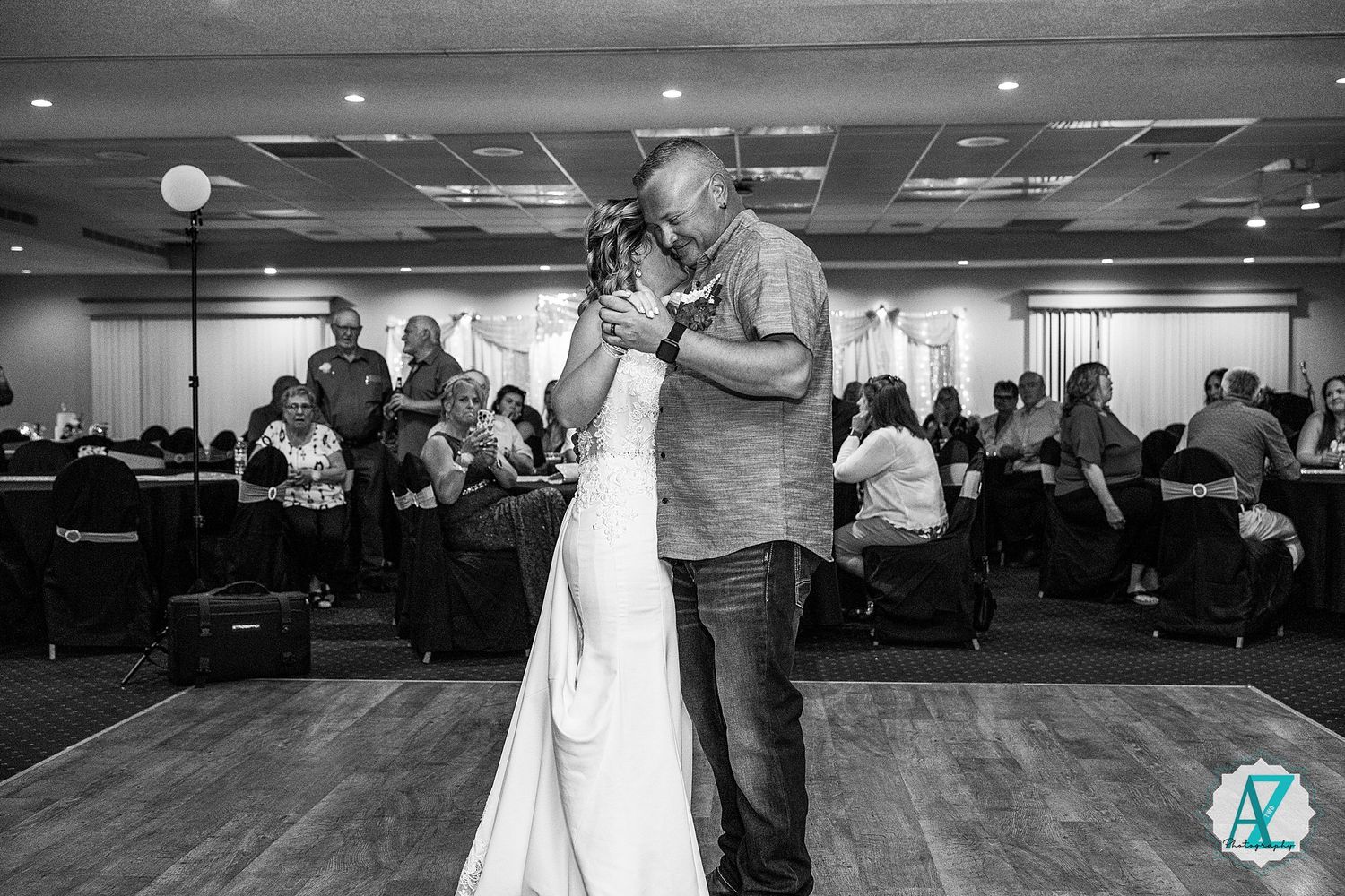 Couples practice ballroom dancing during a social event in a spacious venue with elegant lighting.