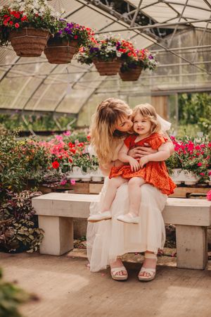 Mother and children hugging and sitting together during their greenhouse photoshoot at Christianson Nursery near Seattle WA