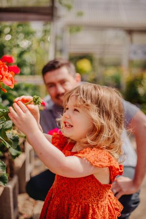 Dad and child together during their greenhouse photoshoot at Christianson Nursery near Seattle, WA
