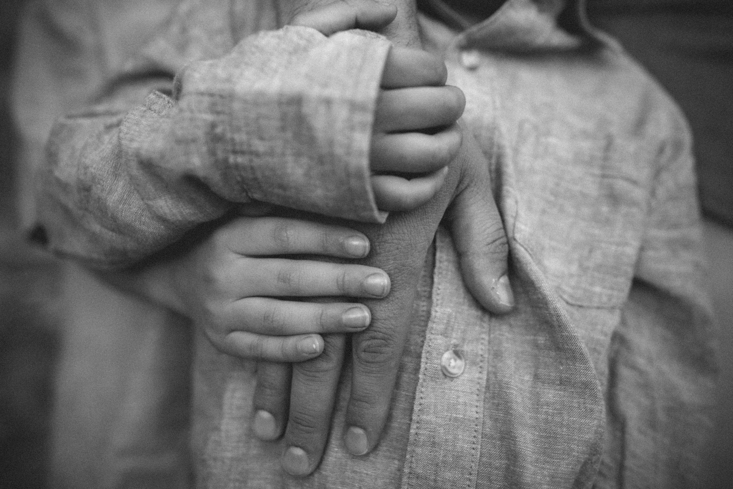Mom and children closeup of hands together during their family photo session in Deception Pass near Seattle Washington