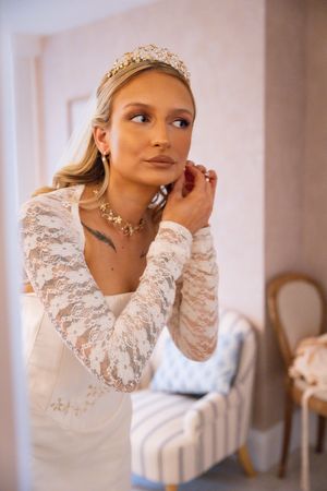 Close-up shots of a bride wearing a white lace gown with ruffled collar and delicate tiara.