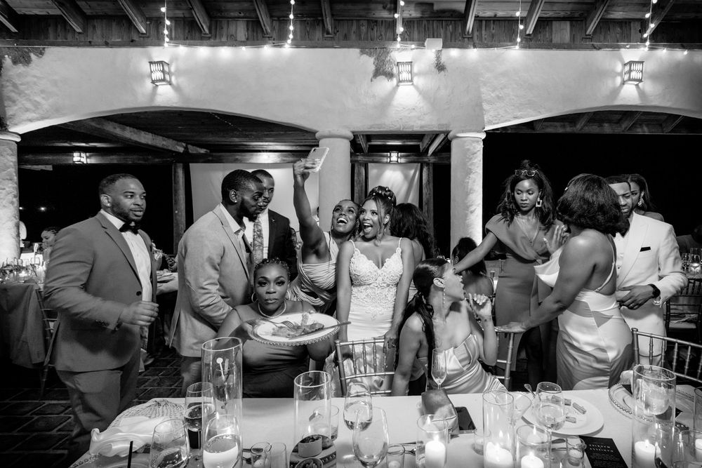 Wedding guests celebrate and dance together on the dance floor during an evening reception celebration.
