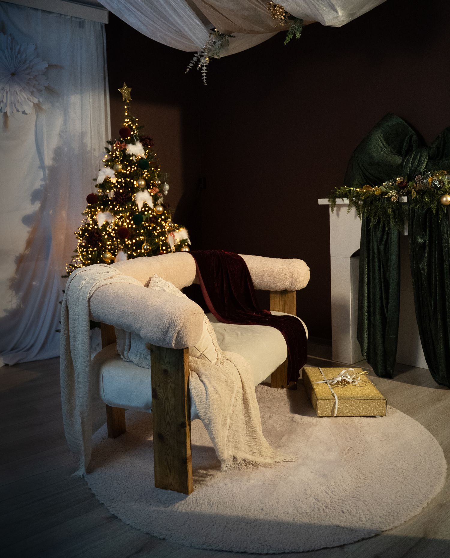White chaise lounge draped in flowing fabric with twinkling lights and decorative elements creating a romantic atmosphere.