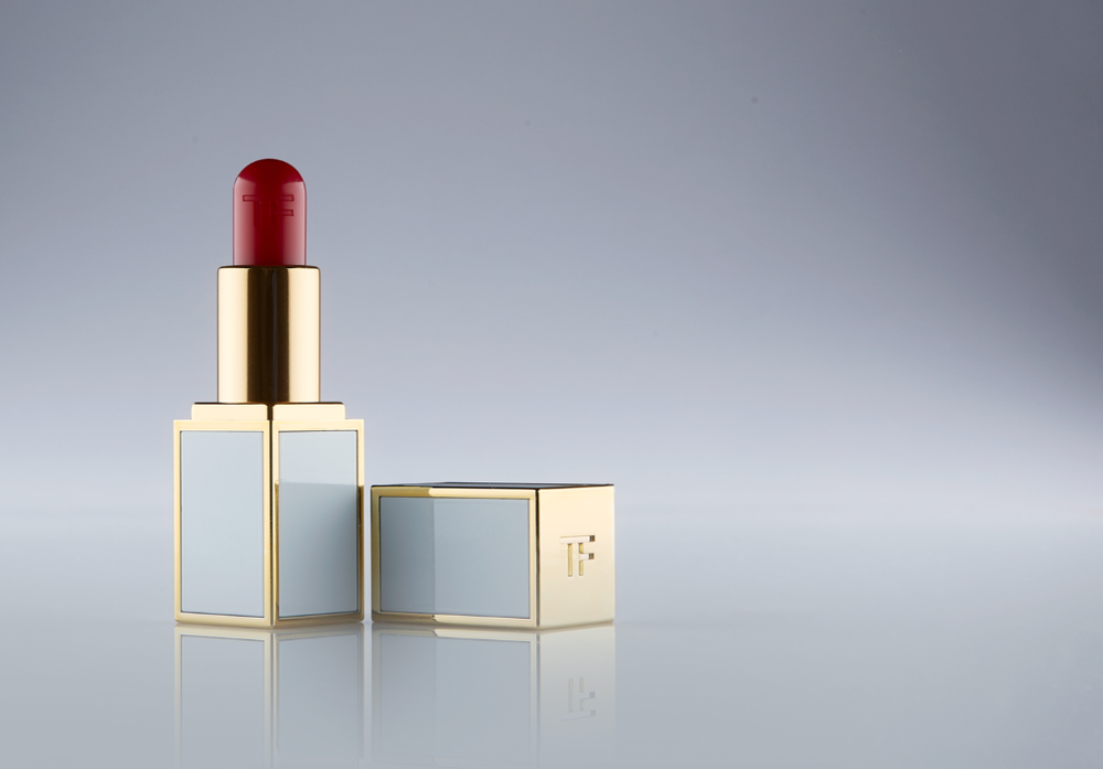 Modern lipstick display with geometric gold frames on light gray background.