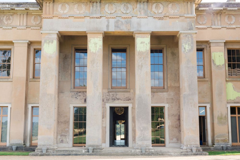 Exterior view of a grand neoclassical building with ornate stone columns and arched windows along its facade at The Grange Northington